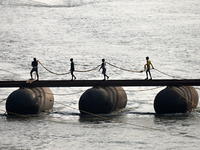 Labourers build a floating pontoon bridge across the river Ganges for devotees ahead of the upcoming Maha Kumbh 2025 festival in Prayagraj,...