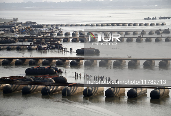 Labourers build a floating pontoon bridge across the river Ganges for devotees ahead of the upcoming Maha Kumbh 2025 festival in Prayagraj,...