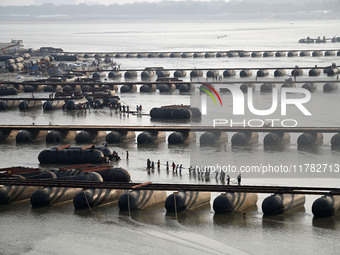 Labourers build a floating pontoon bridge across the river Ganges for devotees ahead of the upcoming Maha Kumbh 2025 festival in Prayagraj,...