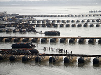 Labourers build a floating pontoon bridge across the river Ganges for devotees ahead of the upcoming Maha Kumbh 2025 festival in Prayagraj,...