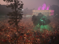 Hindu devotees sit together in front of oil lamps and pray to Shri Shri Loknath Brahmachari, a Hindu saint and philosopher, as they observe...