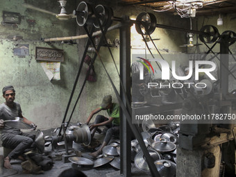 Laborers work inside an aluminum factory in Kamrangirchar, Dhaka, Bangladesh, on November 16, 2024. (