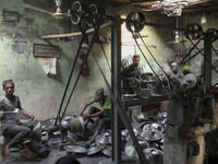 Laborers work inside an aluminum factory in Kamrangirchar, Dhaka, Bangladesh, on November 16, 2024. (