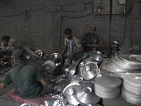 Laborers work inside an aluminum factory in Kamrangirchar, Dhaka, Bangladesh, on November 16, 2024. (