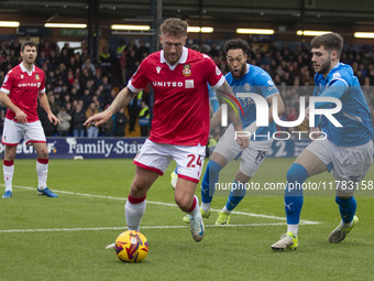 Dan Scarr #24 of Wrexham A.F.C. is challenged by Ethan Pye #15 of Stockport County F.C. during the Sky Bet League 1 match between Stockport...