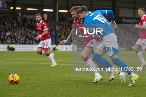 Dan Scarr #24 of Wrexham A.F.C. is challenged by Ethan Pye #15 of Stockport County F.C. during the Sky Bet League 1 match between Stockport...