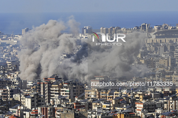 Black smoke rises among the residential buildings following an Israeli airstrike on the Dahieh area in the south of Beirut, Lebanon, on Nove...