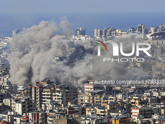 Black smoke rises among the residential buildings following an Israeli airstrike on the Dahieh area in the south of Beirut, Lebanon, on Nove...