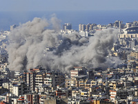 Black smoke rises among the residential buildings following an Israeli airstrike on the Dahieh area in the south of Beirut, Lebanon, on Nove...