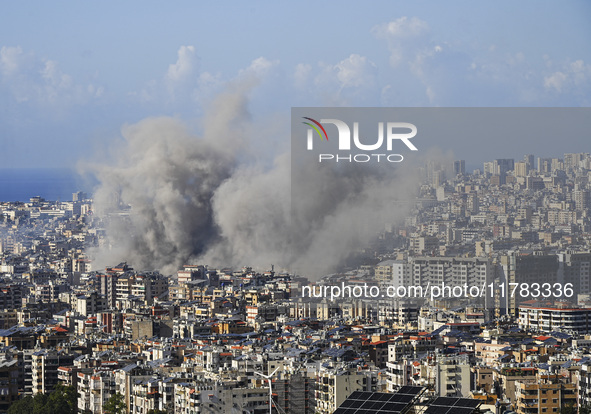 Black smoke rises among the residential buildings following an Israeli airstrike on the Dahieh area in the south of Beirut, Lebanon, on Nove...