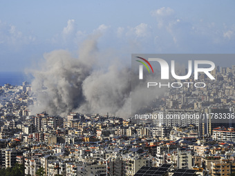 Black smoke rises among the residential buildings following an Israeli airstrike on the Dahieh area in the south of Beirut, Lebanon, on Nove...