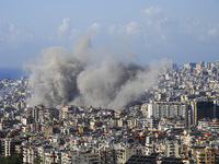 Black smoke rises among the residential buildings following an Israeli airstrike on the Dahieh area in the south of Beirut, Lebanon, on Nove...