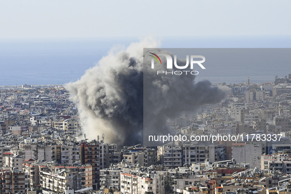 Black smoke rises among the residential buildings following an Israeli airstrike on the Dahieh area in the south of Beirut, Lebanon, on Nove...