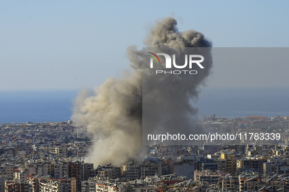 Black smoke rises among the residential buildings following an Israeli airstrike on the Dahieh area in the south of Beirut, Lebanon, on Nove...