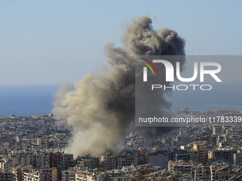 Black smoke rises among the residential buildings following an Israeli airstrike on the Dahieh area in the south of Beirut, Lebanon, on Nove...