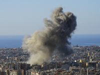 Black smoke rises among the residential buildings following an Israeli airstrike on the Dahieh area in the south of Beirut, Lebanon, on Nove...