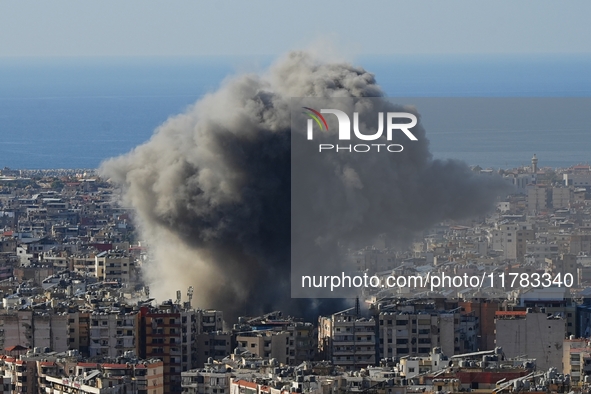 Black smoke rises among the residential buildings following an Israeli airstrike on the Dahieh area in the south of Beirut, Lebanon, on Nove...