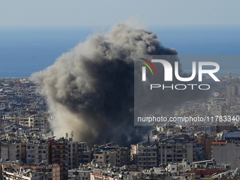 Black smoke rises among the residential buildings following an Israeli airstrike on the Dahieh area in the south of Beirut, Lebanon, on Nove...