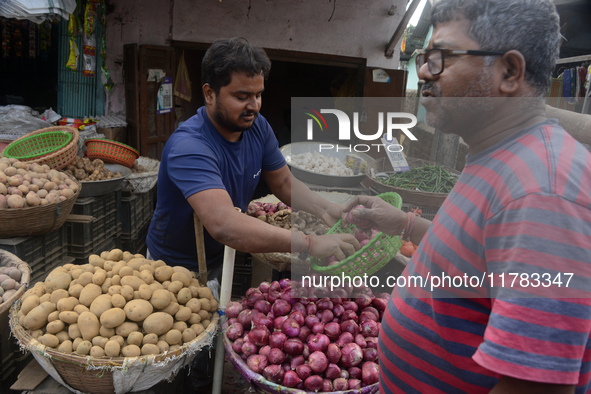 An Indian seller attends to customers while selling onions at his roadside shop in Siliguri, India, on November 16, 2024. Onion prices in th...