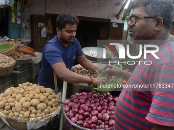 An Indian seller attends to customers while selling onions at his roadside shop in Siliguri, India, on November 16, 2024. Onion prices in th...