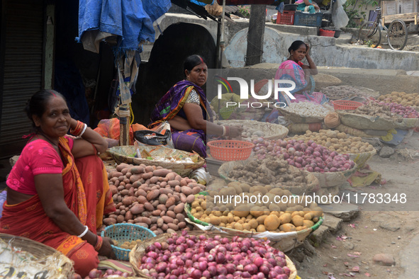 Indian women sellers wait for customers as they sell onions at their roadside shop in Siliguri, India, on November 16, 2024. Onion prices in...