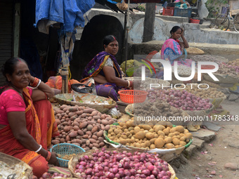 Indian women sellers wait for customers as they sell onions at their roadside shop in Siliguri, India, on November 16, 2024. Onion prices in...