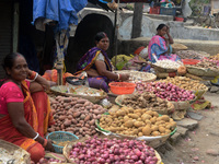 Indian women sellers wait for customers as they sell onions at their roadside shop in Siliguri, India, on November 16, 2024. Onion prices in...