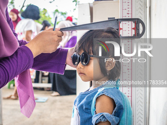 A child is measured during a child stunting prevention program at an integrated services post (POSYANDU) at Perum Panorama Asri in Kalongan...