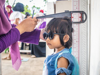 A child is measured during a child stunting prevention program at an integrated services post (POSYANDU) at Perum Panorama Asri in Kalongan...