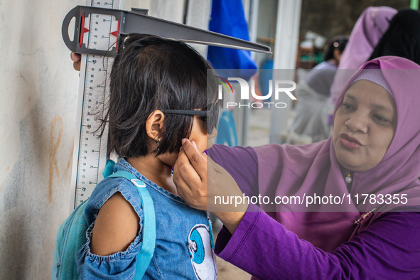 A child is measured during a child stunting prevention program at an integrated services post (POSYANDU) at Perum Panorama Asri in Kalongan...