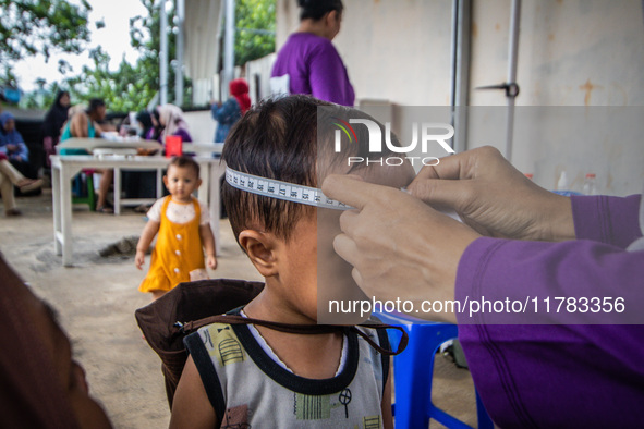 A child is measured during a child stunting prevention program at an integrated services post (POSYANDU) at Perum Panorama Asri in Kalongan...