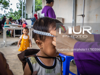 A child is measured during a child stunting prevention program at an integrated services post (POSYANDU) at Perum Panorama Asri in Kalongan...