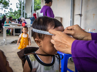 A child is measured during a child stunting prevention program at an integrated services post (POSYANDU) at Perum Panorama Asri in Kalongan...