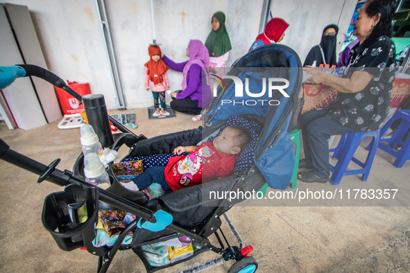 A child is measured during a child stunting prevention program at an integrated services post (POSYANDU) at Perum Panorama Asri in Kalongan...