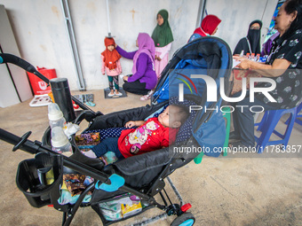 A child is measured during a child stunting prevention program at an integrated services post (POSYANDU) at Perum Panorama Asri in Kalongan...