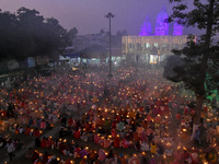 Devotees offer prayers by lighting oil lamps and incense sticks to Sri Loknath Brahmachari on the occasion of Karthik Brata at a Loknath Bra...