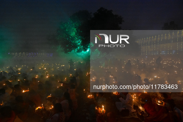 Devotees offer prayers by lighting oil lamps and incense sticks to Sri Loknath Brahmachari on the occasion of Karthik Brata at a Loknath Bra...