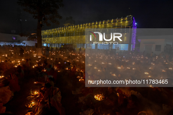 Devotees offer prayers by lighting oil lamps and incense sticks to Sri Loknath Brahmachari on the occasion of Karthik Brata at a Loknath Bra...