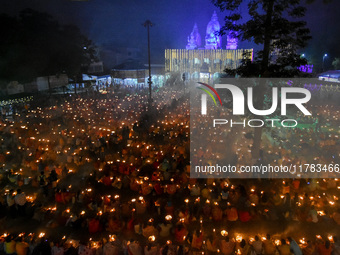 Devotees offer prayers by lighting oil lamps and incense sticks to Sri Loknath Brahmachari on the occasion of Karthik Brata at a Loknath Bra...