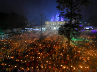 Devotees offer prayers by lighting oil lamps and incense sticks to Sri Loknath Brahmachari on the occasion of Karthik Brata at a Loknath Bra...