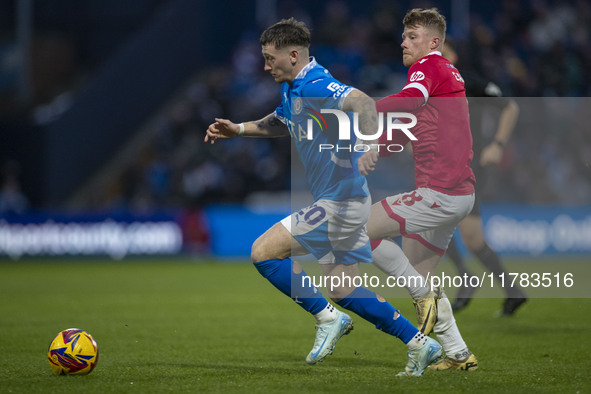 Louie Barry #20 of Stockport County F.C. is challenged by Andy Cannon #8 of Wrexham A.F.C. during the Sky Bet League 1 match between Stockpo...