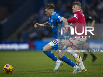 Louie Barry #20 of Stockport County F.C. is challenged by Andy Cannon #8 of Wrexham A.F.C. during the Sky Bet League 1 match between Stockpo...