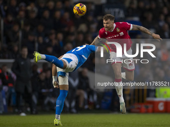 Dan Scarr, number 24 of Wrexham A.F.C., heads the ball during the Sky Bet League 1 match between Stockport County and Wrexham at the Edgeley...