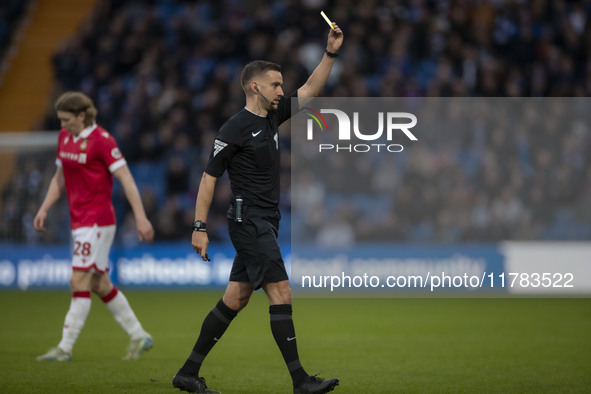 Referee Thomas Kirk shows a yellow card to Andy Cannon #8 of Wrexham A.F.C. during the Sky Bet League 1 match between Stockport County and W...