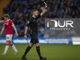 Referee Thomas Kirk shows a yellow card to Andy Cannon #8 of Wrexham A.F.C. during the Sky Bet League 1 match between Stockport County and W...