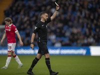 Referee Thomas Kirk shows a yellow card to Andy Cannon #8 of Wrexham A.F.C. during the Sky Bet League 1 match between Stockport County and W...