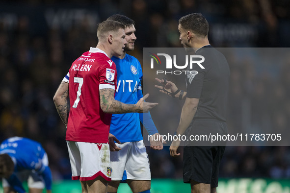 Referee Thomas Kirk talks to James McClean #7 of Wrexham A.F.C. during the Sky Bet League 1 match between Stockport County and Wrexham at th...