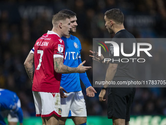 Referee Thomas Kirk talks to James McClean #7 of Wrexham A.F.C. during the Sky Bet League 1 match between Stockport County and Wrexham at th...