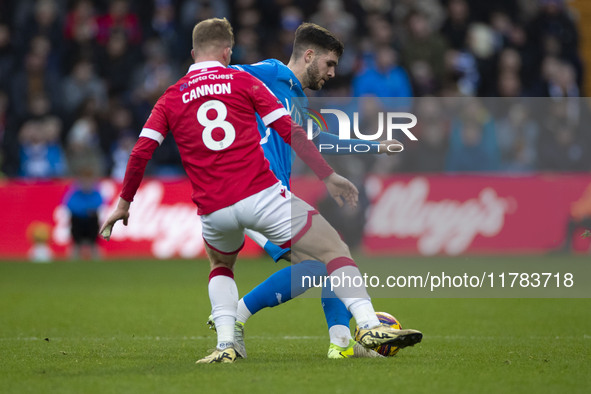 Ethan Pye #15 of Stockport County F.C. is challenged by Andy Cannon #8 of Wrexham A.F.C. during the Sky Bet League 1 match between Stockport...