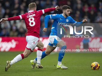 Ethan Pye #15 of Stockport County F.C. is challenged by Andy Cannon #8 of Wrexham A.F.C. during the Sky Bet League 1 match between Stockport...